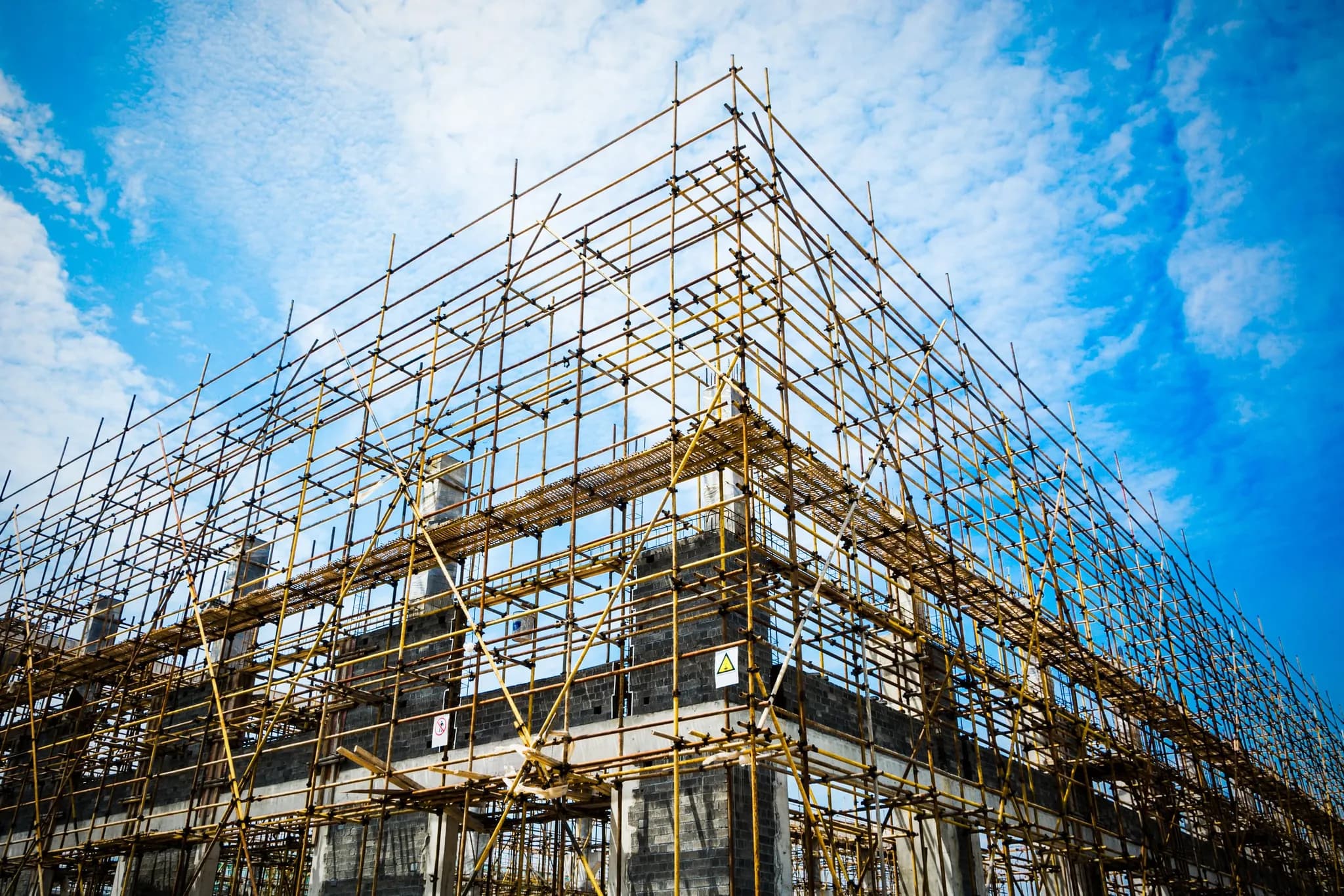 Steel structural framing rising against a bright blue sky