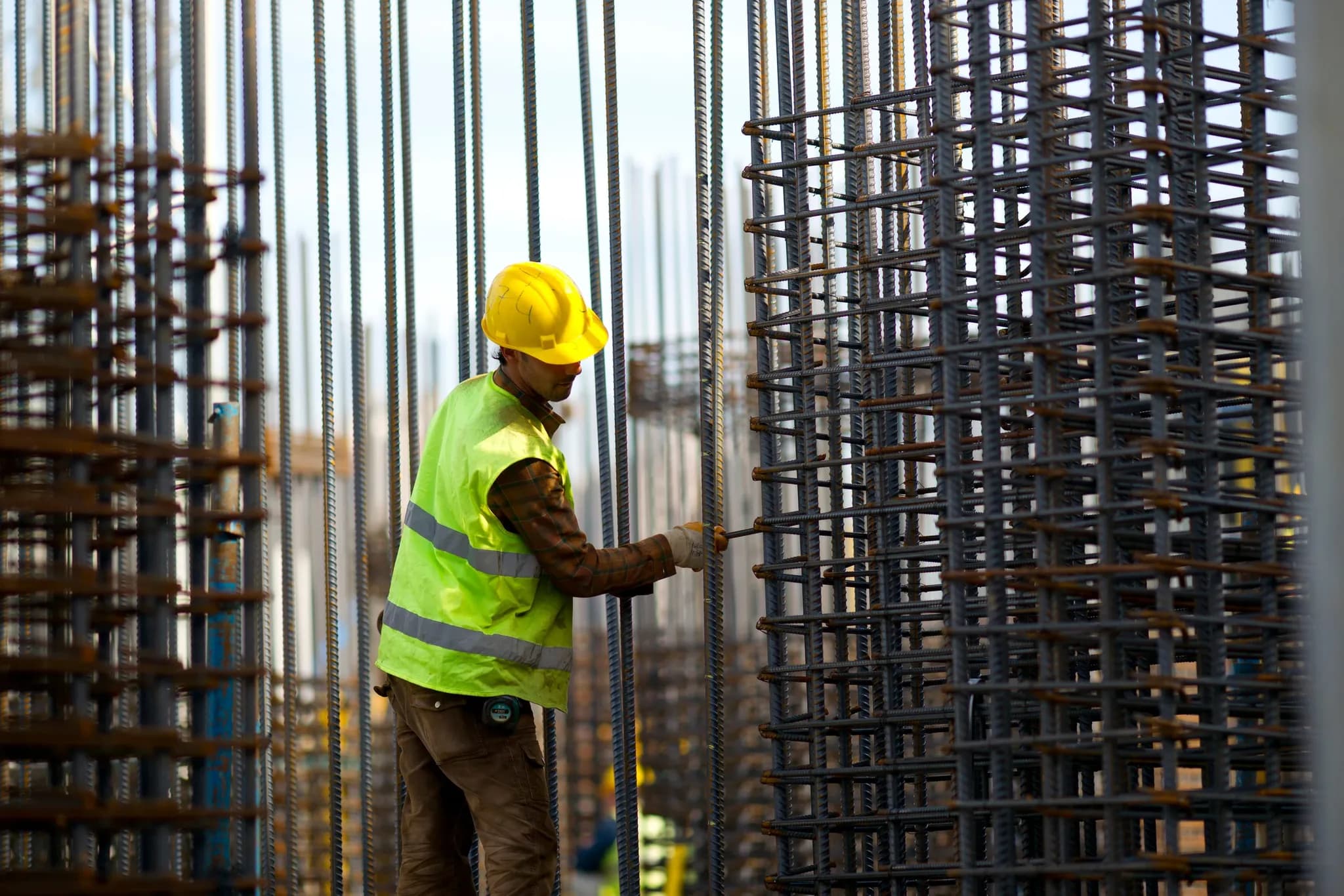 A worker assembling a reinforcement cage on an active build